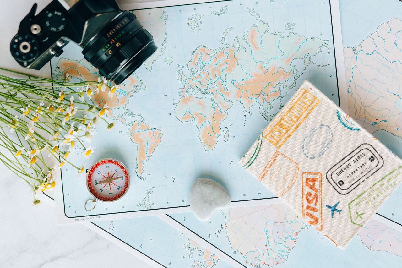 The Art of Drawing Readers In: Your attractive post title goes here Flat lay of travel essentials: maps, camera, compass, and travel journal for planning adventures.